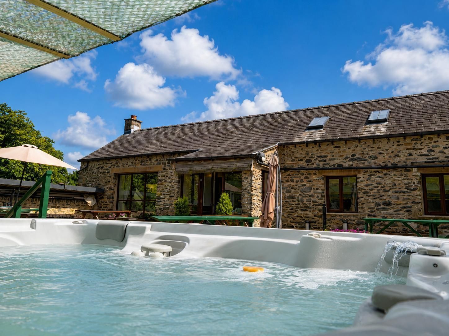 A stone building with a hot tub in front.