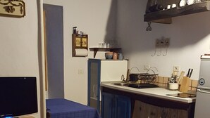 A compact kitchen with a dining area, a small table, and a TV. - RURAL HOUSE FINCA PARAISO. for a fantastic stay north of Tenerife (San Cristóbal de La Laguna)