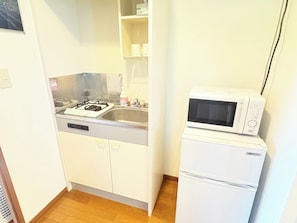 Kylskåp, mikrovågsugn, spishäll och grytor/köksredskap