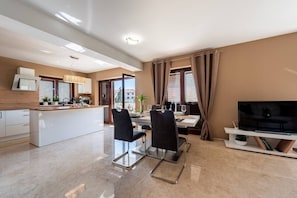 Een modern appartement met keuken, eethoek en woonkamer.