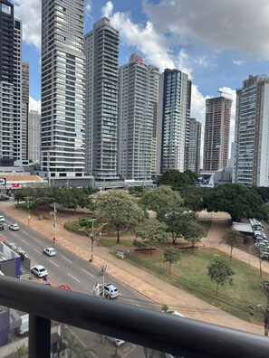 Un paisaje urbano con rascacielos, una calle con coches y una acera para peatones.