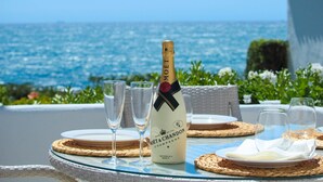 A bottle of Moët & Chandon champagne on a table with glasses and plates, overlooking the sea. - Rocas del Mar I - Front Line Beach (Mijas Costa)