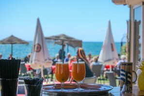 A table with two glasses of amber liquid, a metal tray, and a metal bell. - Rocas del Mar I - Front Line Beach (Mijas Costa)