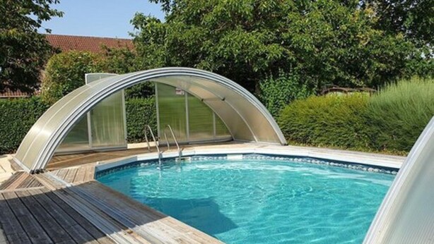 A swimming pool with a wooden deck and a glass-enclosed hot tub. - Au Fil des Lacs (Précy-Saint-Martin)