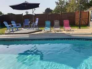 A swimming pool with a tiled edge, surrounded by a wooden fence. - Au Fil des Lacs (Précy-Saint-Martin)