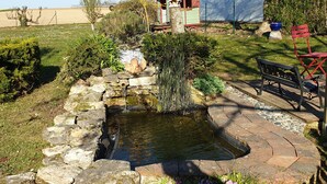 A garden with a stone pond, a wooden bench, and a small shed. - Au Fil des Lacs (Précy-Saint-Martin)