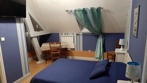 A bedroom with a bed, a desk, a chair, a TV, and a window with curtains. - Au Fil des Lacs (Précy-Saint-Martin)