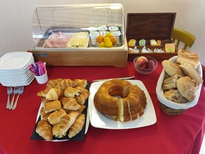 A breakfast buffet with croissants, a bundt cake, and various fruits and cheeses. - Au Fil des Lacs (Précy-Saint-Martin)