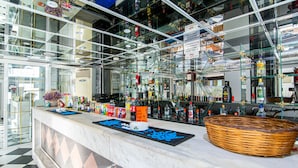 A bar area with a glass counter, various bottles, and a decorative basket. - ICandy Sol (Hersonissos)