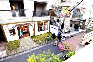 A building with a ground-floor retail space and a staircase leading to an upper floor.