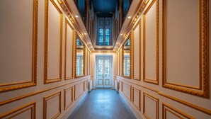 A hallway with ornate gold trim, a tiled floor, and a double door at the end. - 5 Star Apart Hotel (Tbilisi)