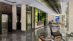 A modern lobby with a reception desk, seating area, and an elevator. - Royal Malioboro Yogyakarta by Aston (Yogyakarta)