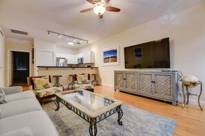 A living room with a sofa, coffee table, TV, and a cabinet.