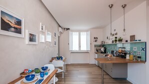 Una cocina moderna con encimera de madera, comedor con mesa y sillas, y vistas al exterior a través de un ventanal amplio.