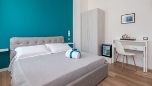 Una habitación de hotel moderna con cama, escritorio y silla.