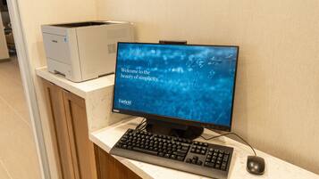 A desktop computer with a monitor displaying a welcome message, a keyboard, and a mouse on a counter.