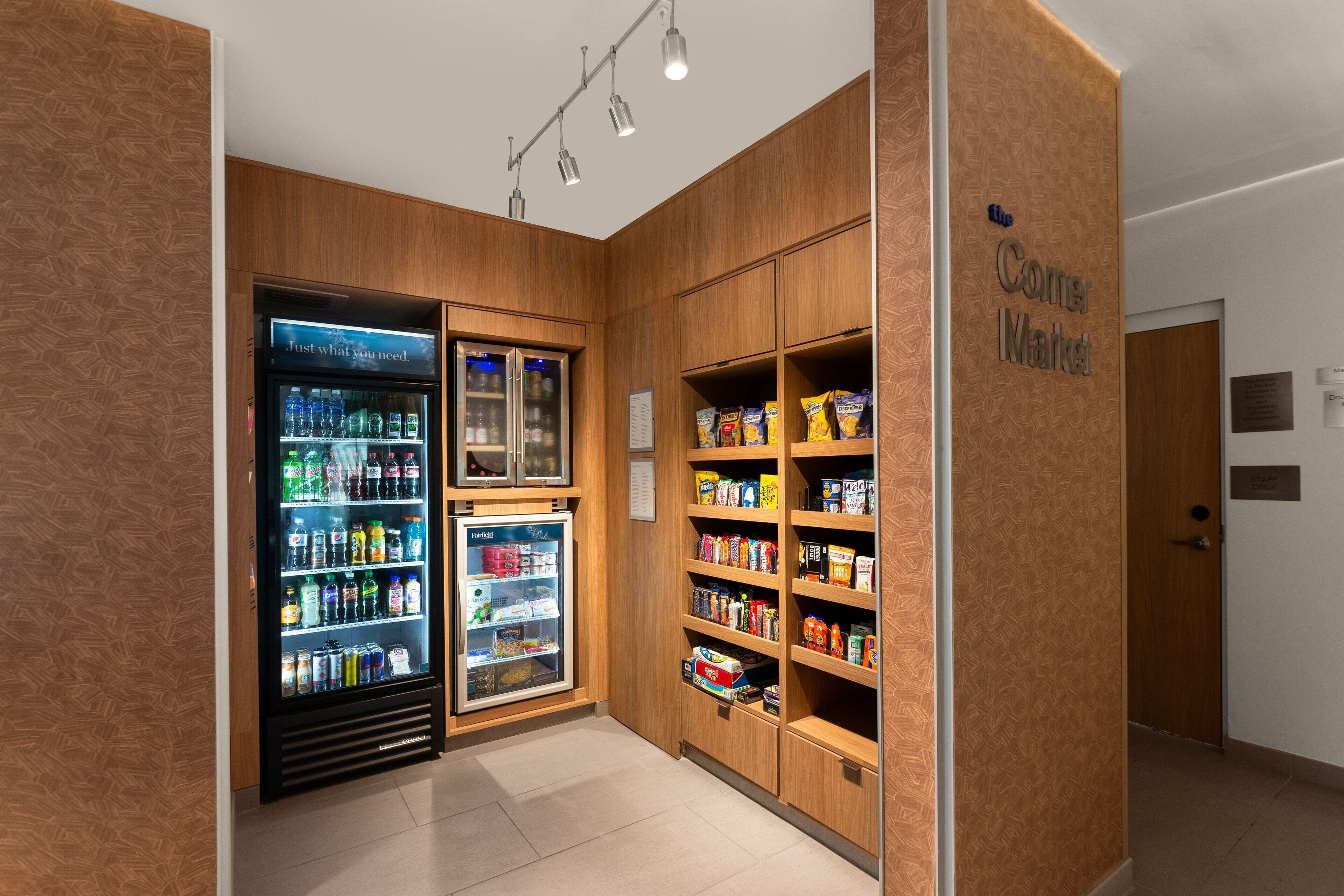 A snack bar with refrigerated drinks and shelves stocked with snacks.