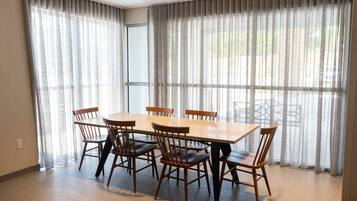 A dining area with a rectangular table and six wooden chairs.