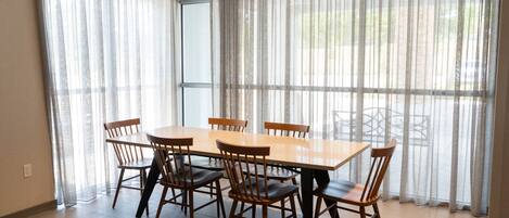 A dining area with a rectangular table and six wooden chairs.