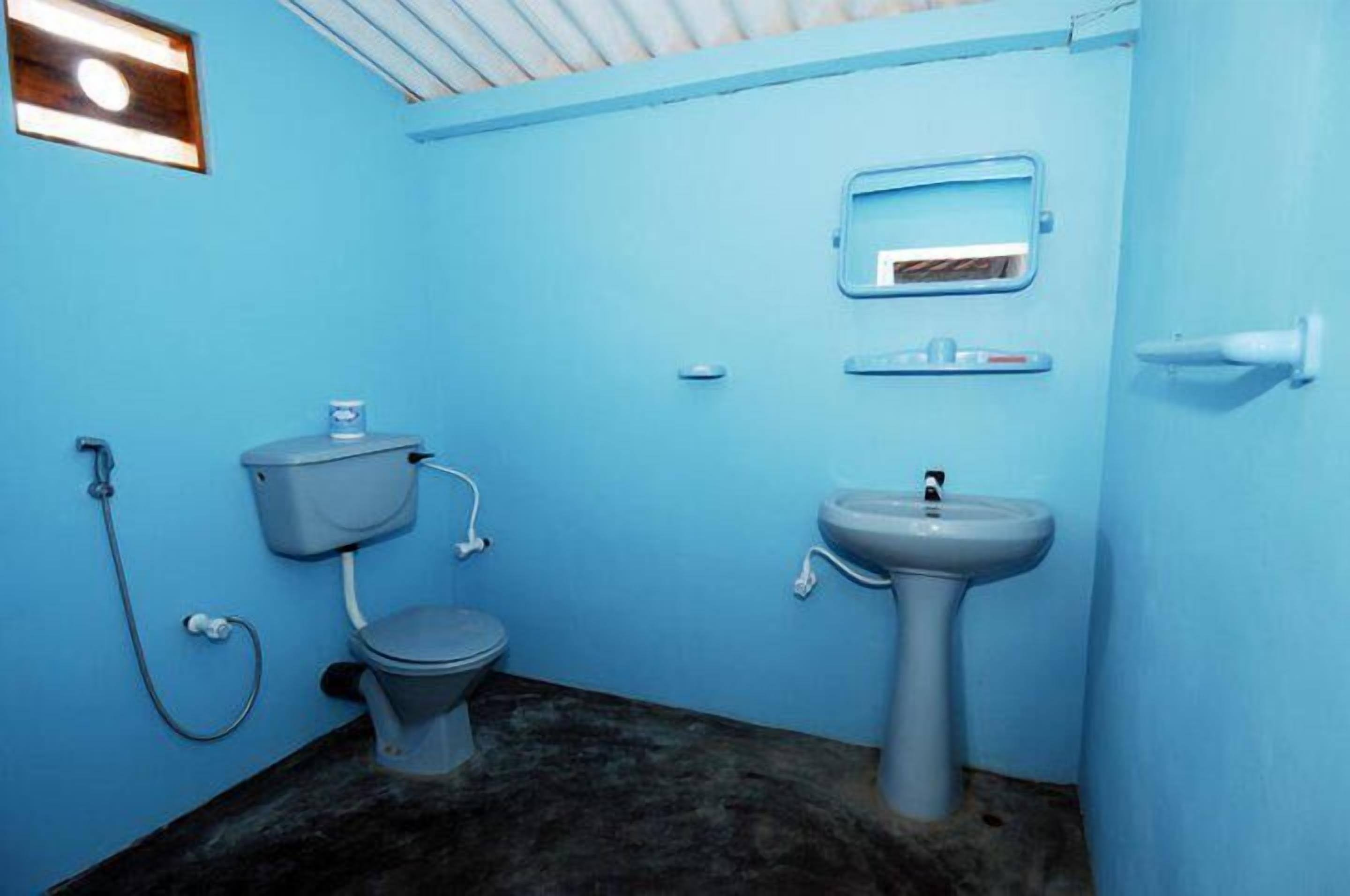 Un baño pequeño con inodoro, lavabo y espejo.