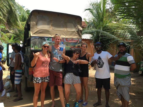 Un grupo de personas posando frente a un vehículo de safari con un letrero que dice 'Fiji Safari'.