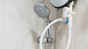 A shower with a handheld showerhead and a wall-mounted control knob. - Hudhu Velaa (Dhonfanu)