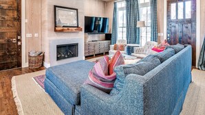 A cozy living room with a fireplace, a large TV, and comfortable seating. - Carlton Landing-Spacious home on Boulevard (Eufaula)