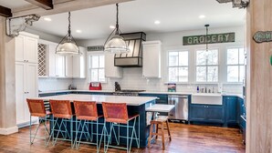 A spacious kitchen with a central island, wooden flooring, and a view of the outdoors. - Carlton Landing-Spacious home on Boulevard (Eufaula)