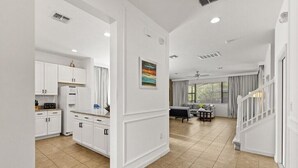 Un amplio espacio de sala de estar con cocina, mesa de comedor y escalera.