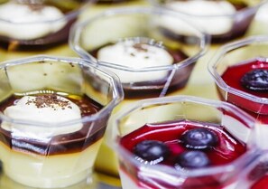 Un espositore di dolci con diversi parfait in bicchieri trasparenti.