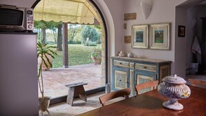 Un'area pranzo con tavolo, sedie, un mobile di stile vintage e un vaso decorativo.