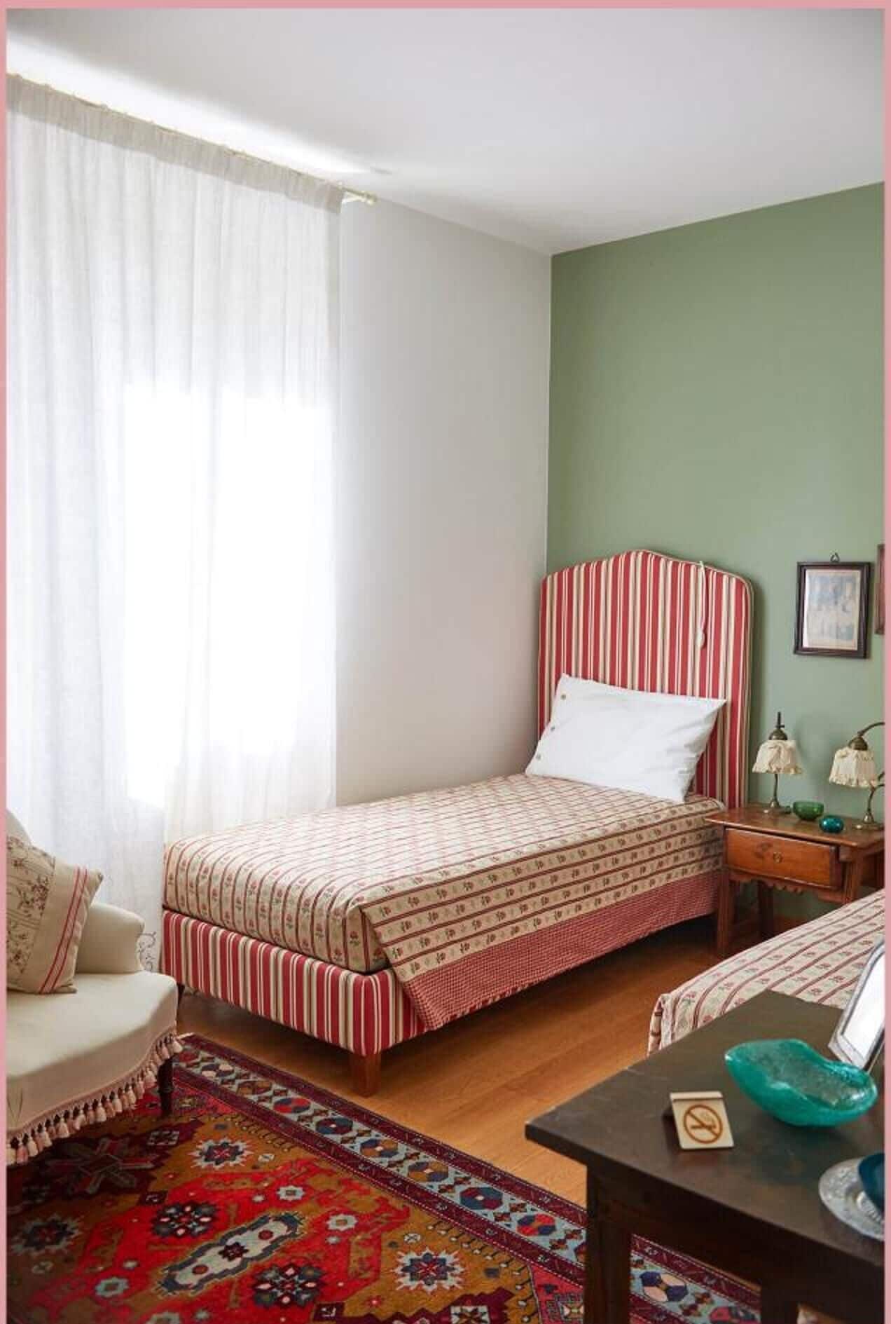 Une petite chambre à coucher accueillante, avec un lit simple, une chaise, une table de chevet et une table avec une lampe.