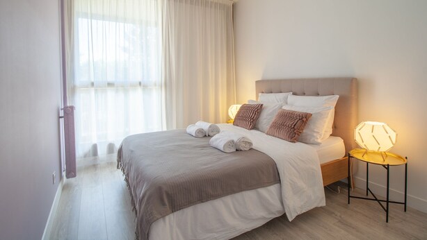 A neatly made bed with a headboard, a bedside lamp, and a window with sheer curtains. - ✨Mountain Suite ✨ stylish apartment with WiFi and Parking 🅿️ (Seynod)