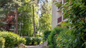 A pathway flanked by lush greenery and a multi-story building with balconies. - ✨Mountain Suite ✨ stylish apartment with WiFi and Parking 🅿️ (Seynod)