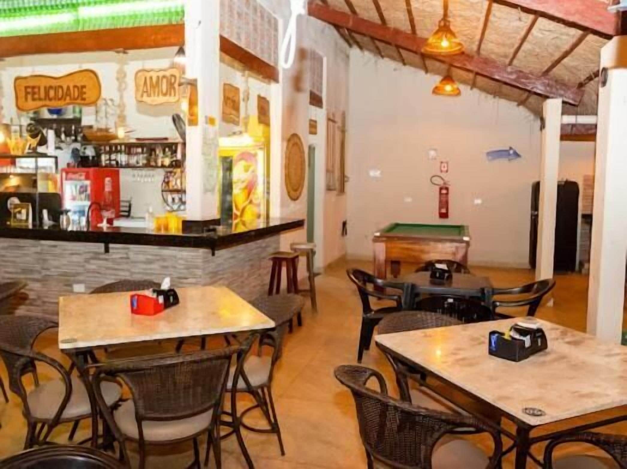 A restaurant with a bar area, tables, and chairs.