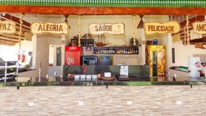 Eine Barbereich mit Schildern, auf denen 'PAZ', 'ALEGRIA', 'SAÚDE' und 'FELICIDADE' stehen.