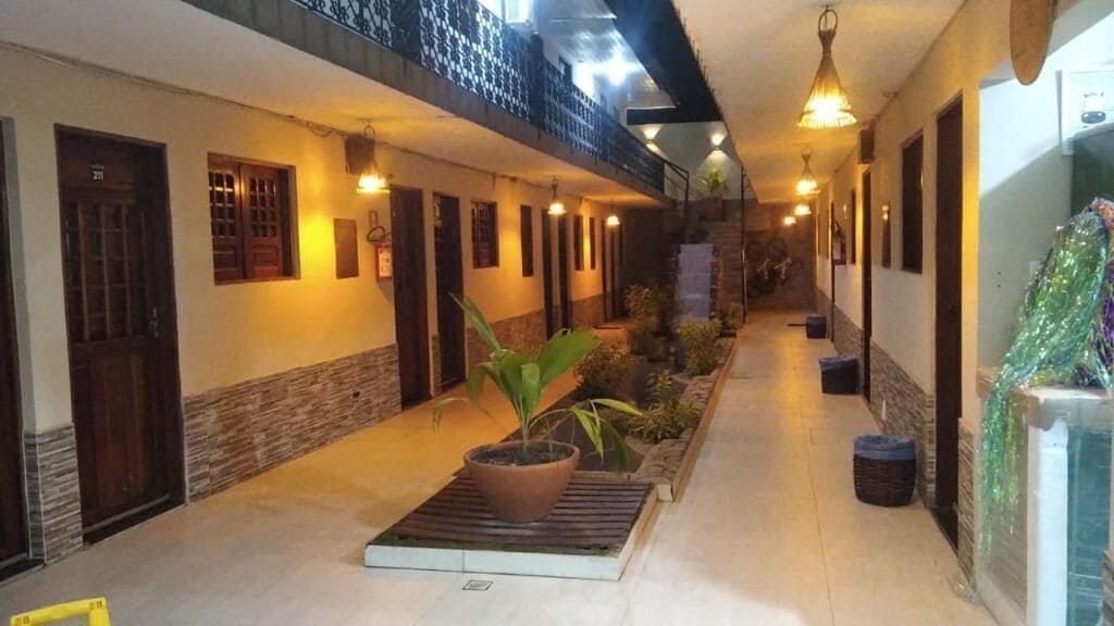 A corridor with doors, potted plants, and a water feature.
