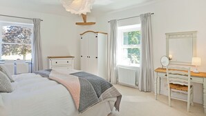 A bedroom with a bed, dresser, and a mirror. - An immaculately presented, 2 bedroom property with river views. (Gargrave)