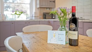 A wooden table with a wine bottle and a card in a glass vase. - An immaculately presented, 2 bedroom property with river views. (Gargrave)