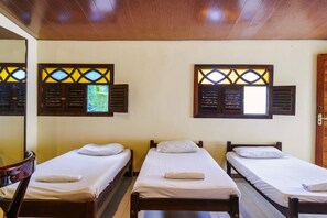 A room with three single beds, wooden headboards, and windows with decorative shutters. - Macaco Surf Hostel (Tibau do Sul)