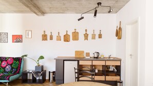 A compact kitchen with a wooden countertop, a sink, and a dining area with a round table.