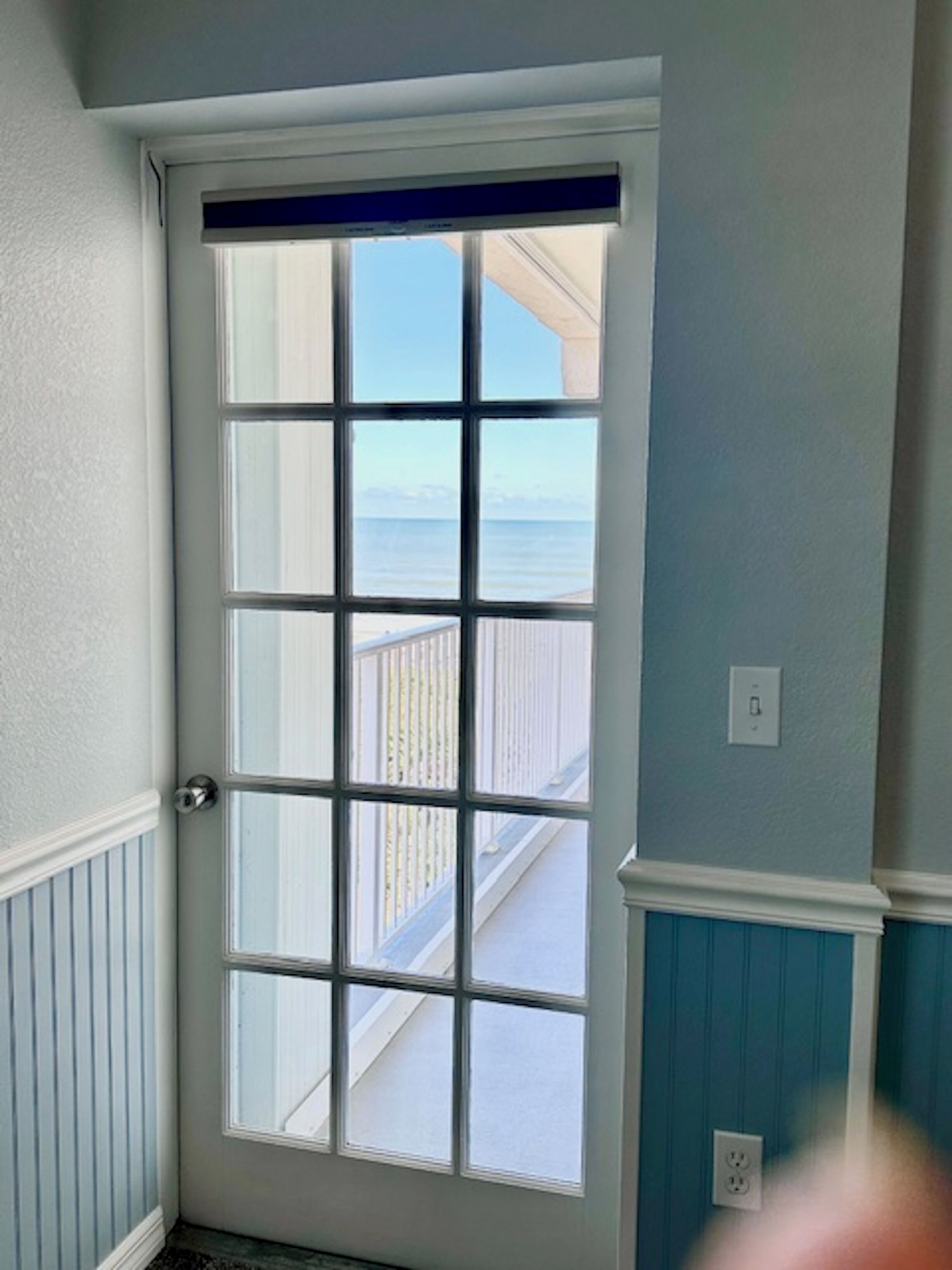 Une porte donnant sur un balcon et une balustrade.