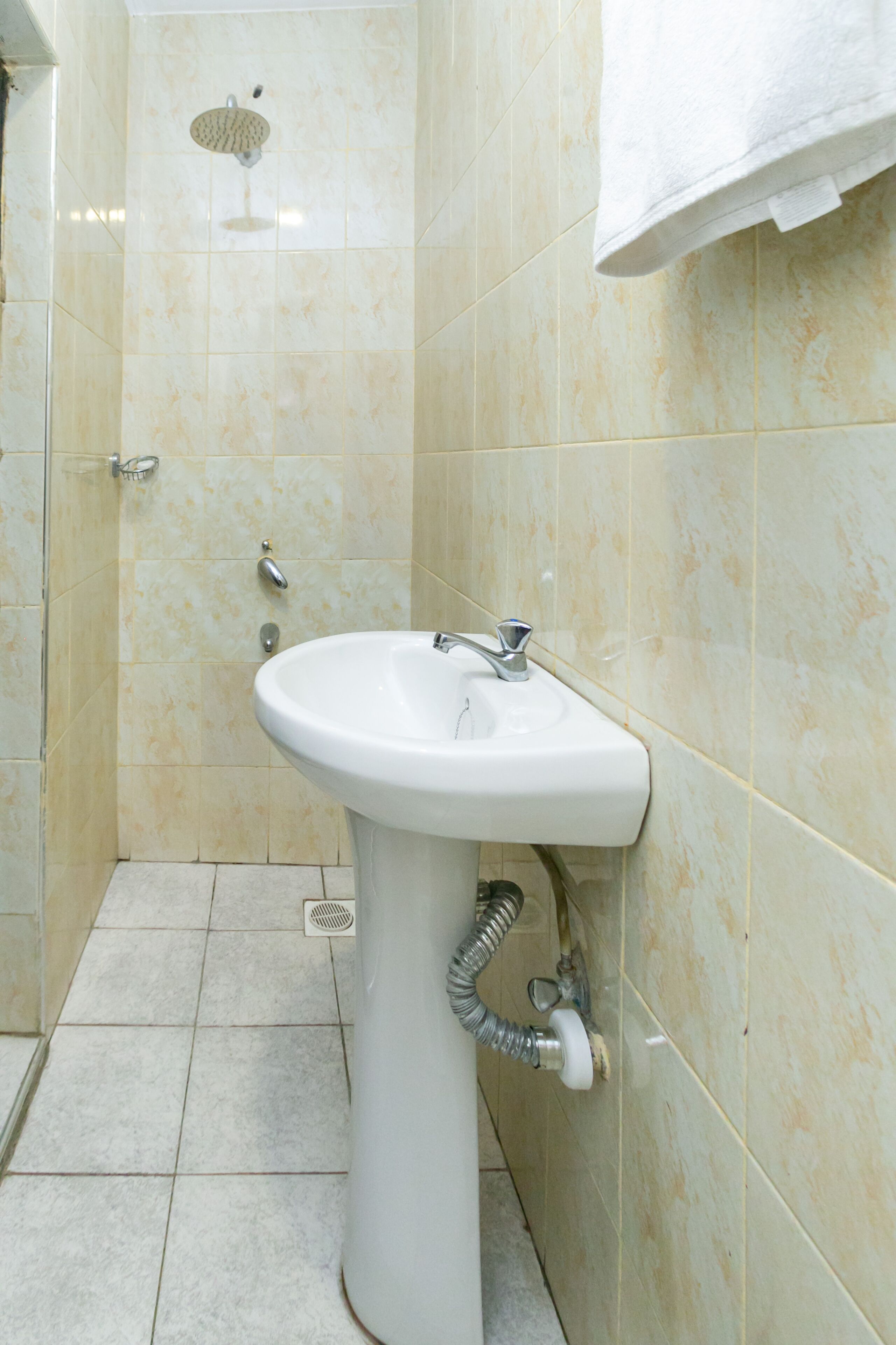 A bathroom with a sink, shower, and tiled walls.