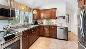 Una cocina moderna con electrodomésticos de acero inoxidable, armarios de madera y un lavamanos de estilo rústico.