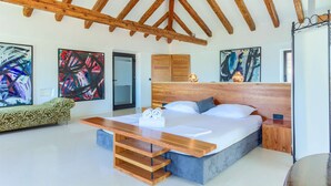 A modern bedroom with a wooden ceiling, a large bed with a wooden headboard, and abstract paintings on the walls. - Villa Cubismo - with a pool for 18 guests, close to restaurants and cafes by MyWaycation (Tkon)