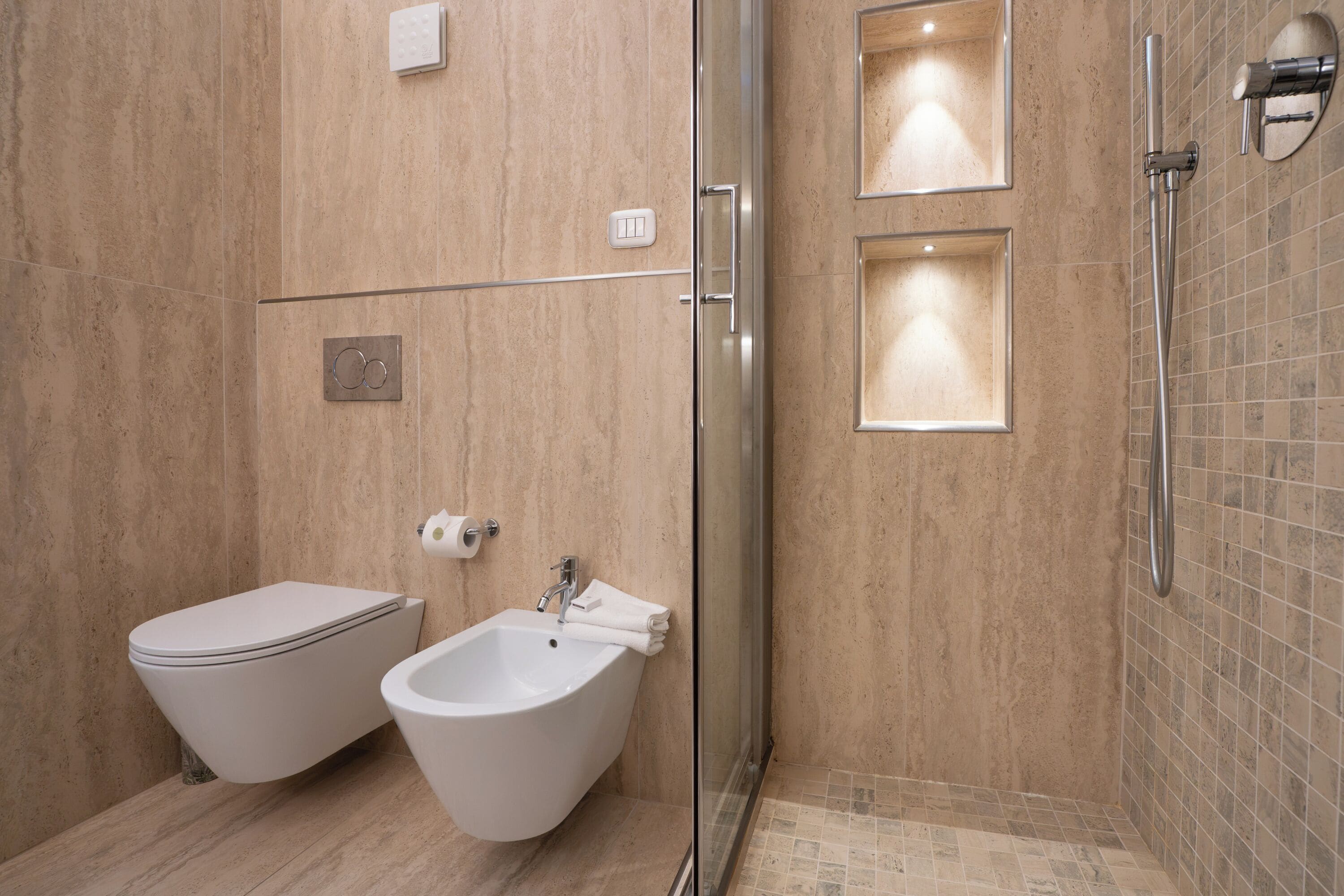 Ein modernes Badezimmer mit integriertem Bidet, WC und einer Duschkabine.