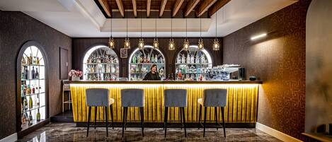 A bar area with a counter, bar stools, and a bartender.