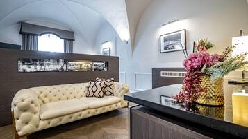 Ein modernes Wohnzimmer mit einer gepolsterten Couch, einer Holzkommode und einer dekorativen Vase mit Blumen.