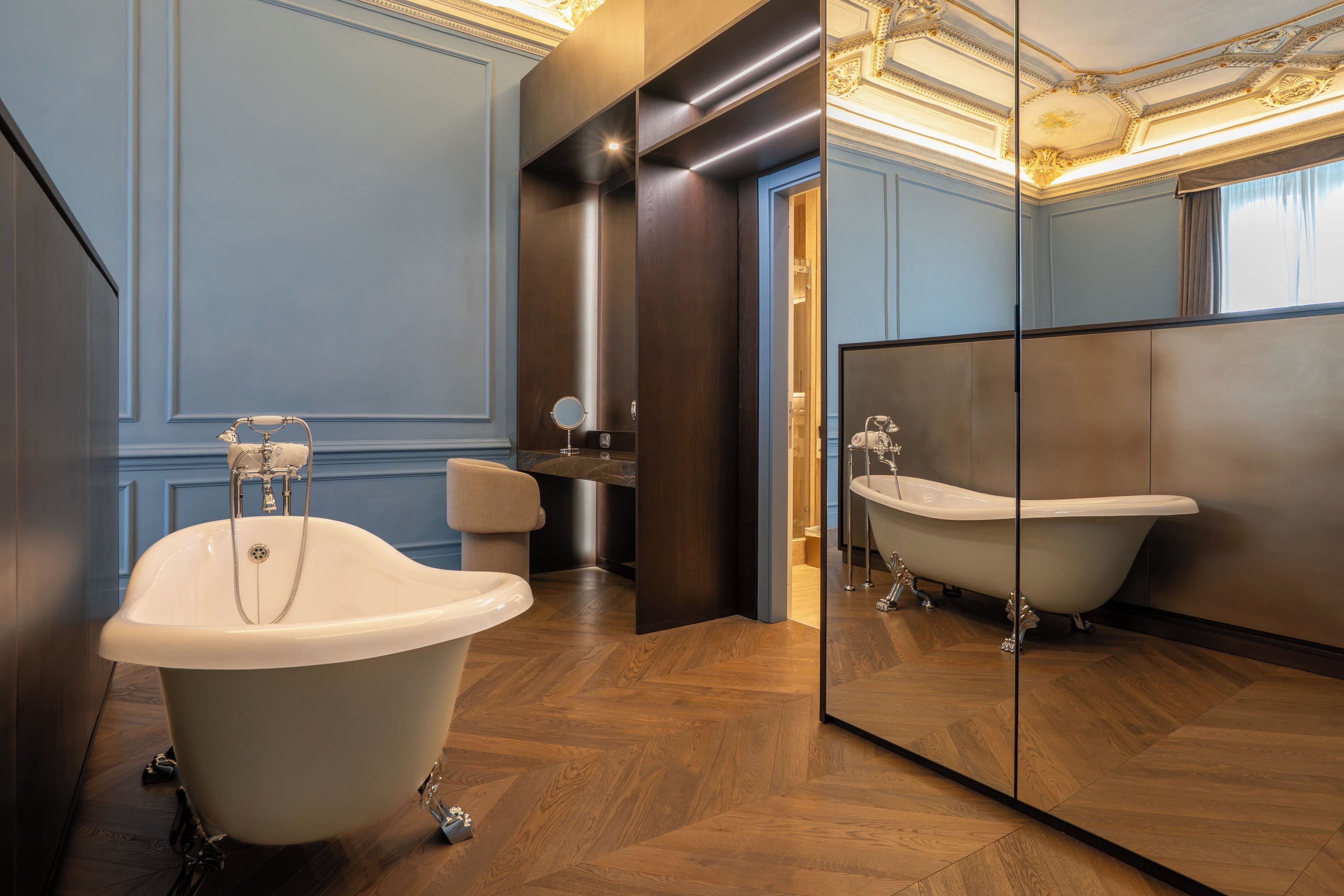 Une salle de bain moderne avec une baignoire sur pieds, un miroir et un meuble-lavabo.