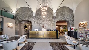 Eine Lobby mit Empfangstresen, Sitzgelegenheiten und einer großen Chandelier.